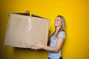 a woman holding a large moving boxes