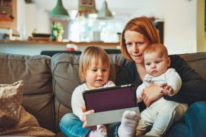 two babies and woman sitting on sofa