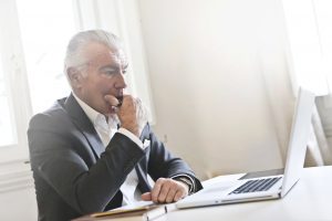 A man looking at his computer with concern