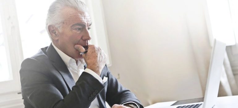 A man looking at his computer with concern