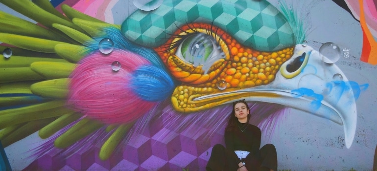 A woman posing by the mural