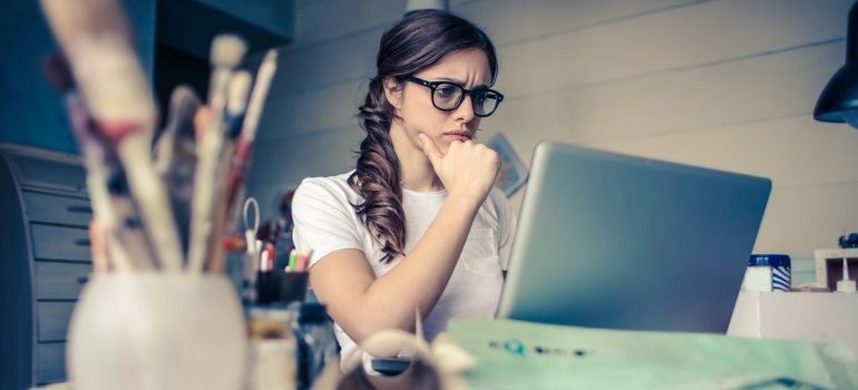 A woman looking at her computer with concern