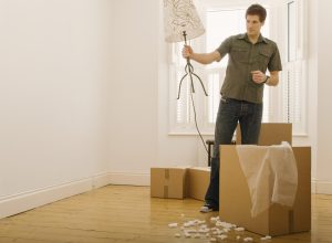 person holding a lamp near moving box