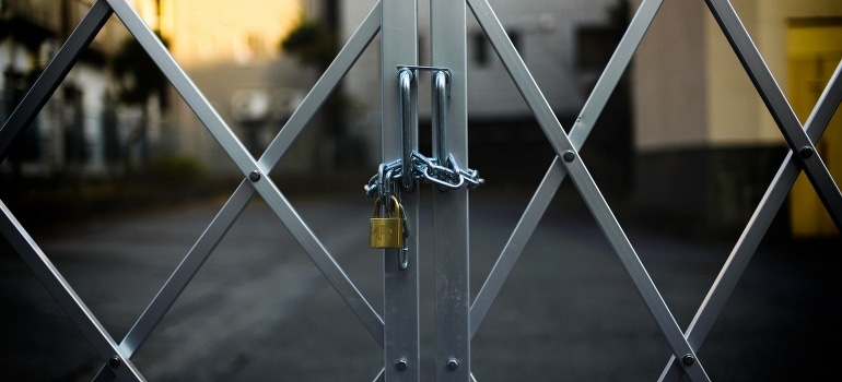 Gray steel gate closed with padlock