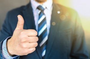 Man in a suit with a thumb up