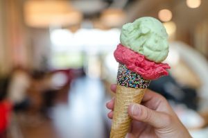 person holding an ice cream cone with three flavors