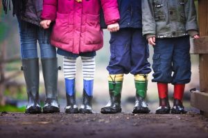 four kids standing in dirt holding hands