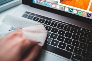 person cleaning the laptop