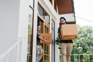 Two people moving boxes after they find a cheap storage unit