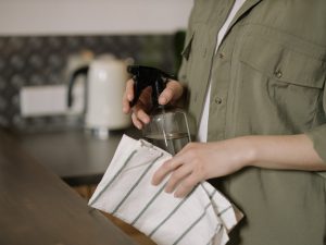 person holding a towel and a spray bottle