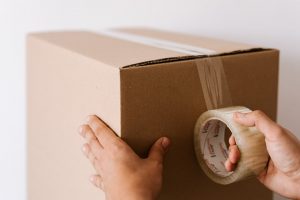 a person duct taping a moving box