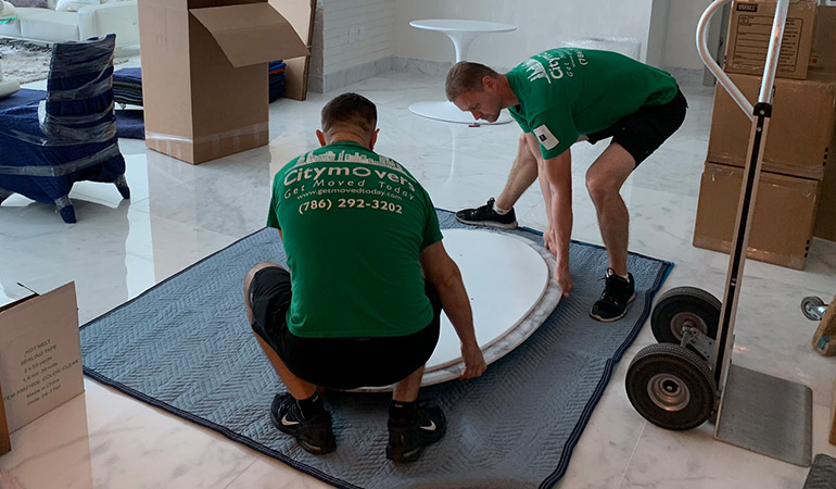 Two movers handling a very fragile table. 