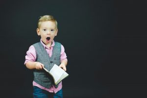A kid holding a notebook with a list of places for moving with your family