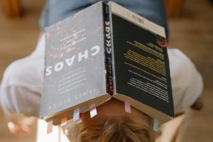 Book called Chaos on a persons head