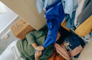 person under a pile of clothes