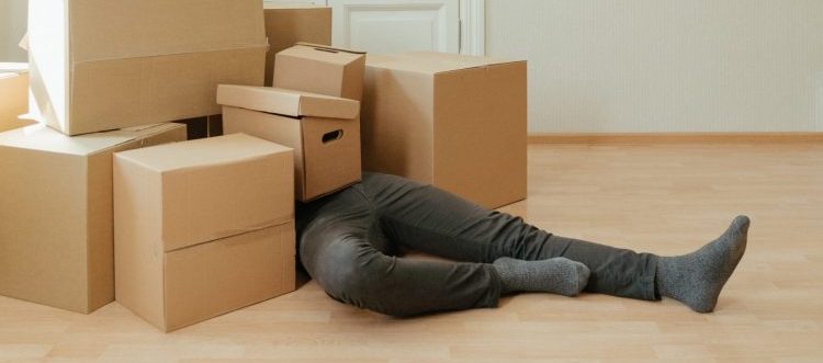 A person covered in moving boxes.