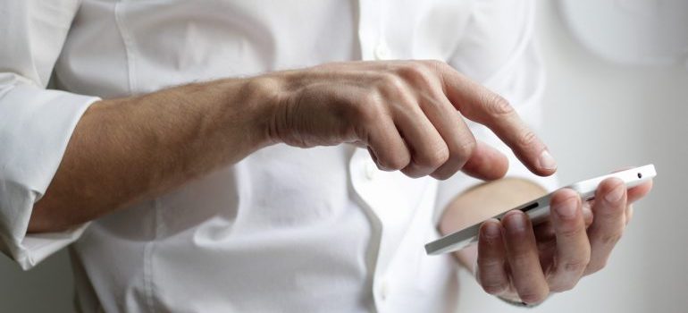 Man using a phone to research moving companies Miami prices