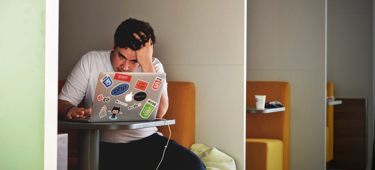 man in white shirt using macbook