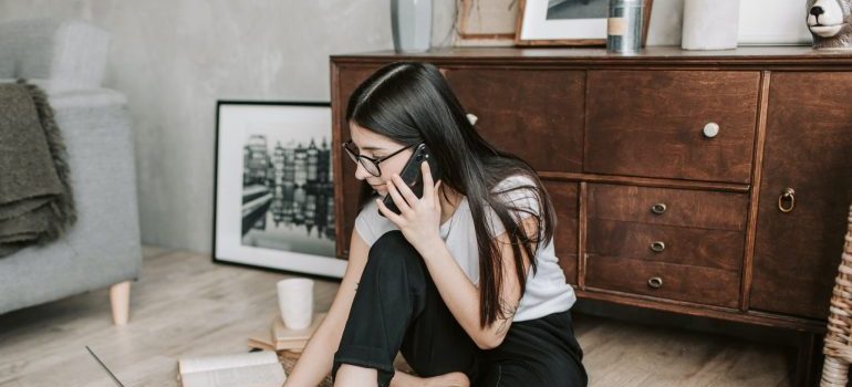 woman-using-her-laptop-while-having-a-conversation-over-the-phone