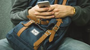 a man holding a phone - Pack your essentials bag