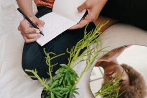 a woman writing down on how to protect the condition of a plant 