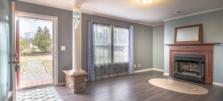 a living room with fireplace and open main door