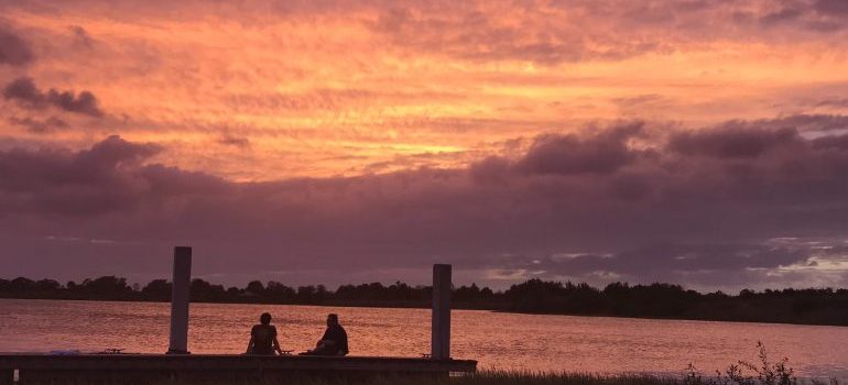 Two persons sitting next to the beach, enjoying the sea as they finished moving to Boca Raton in 2021