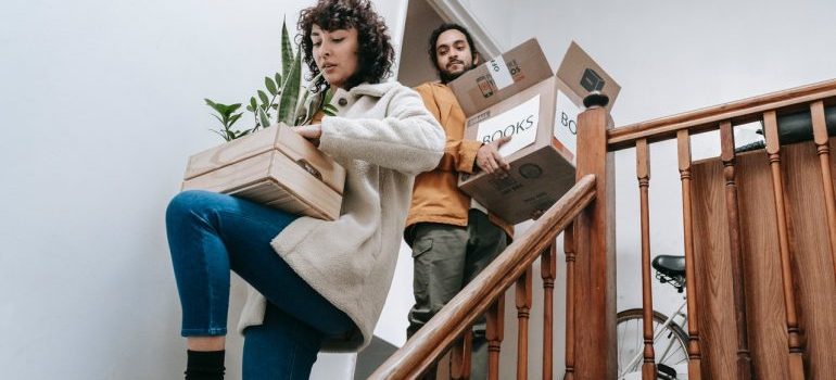 People carrying boxes down the stairs