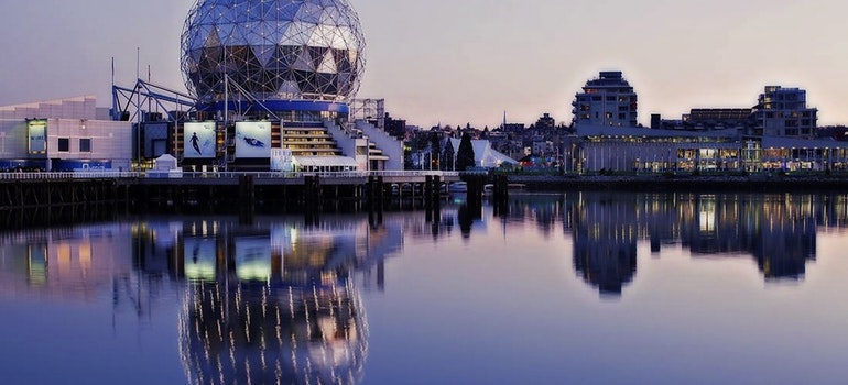 A modern city in Canada behind a lake during a sunset