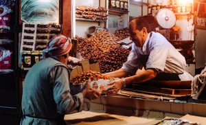 a man selling fruits to a lady