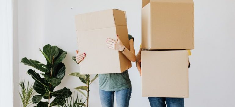 Couple carrying boxes and preparing for moving from Florida to Texas.