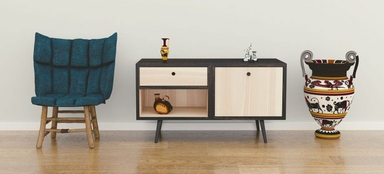 A chair, an end table, and a vase to be packed with packing services Miami.