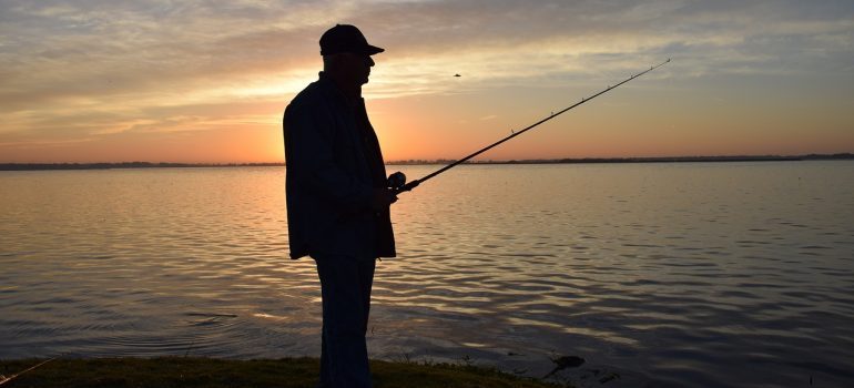 A silhouette of a man fishing at sunset