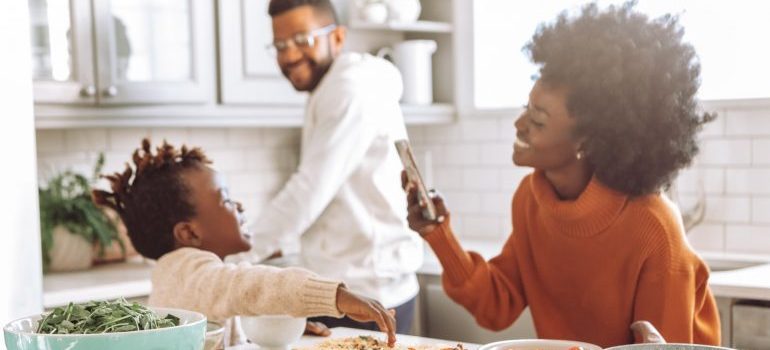 A family sitting at the kitchen table, smiling