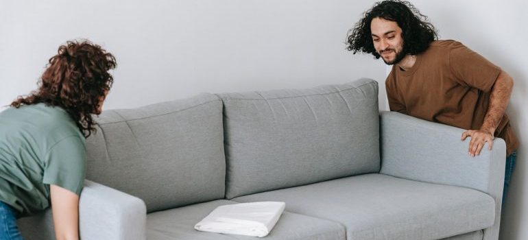 A couple moving a sofa - home staging with self-storage