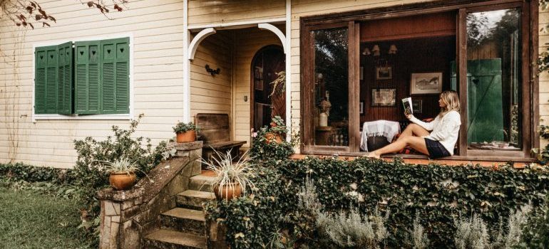 woman sitting on a porch and reading