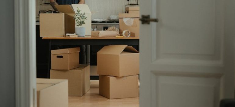 A man packing belongings in moving boxes