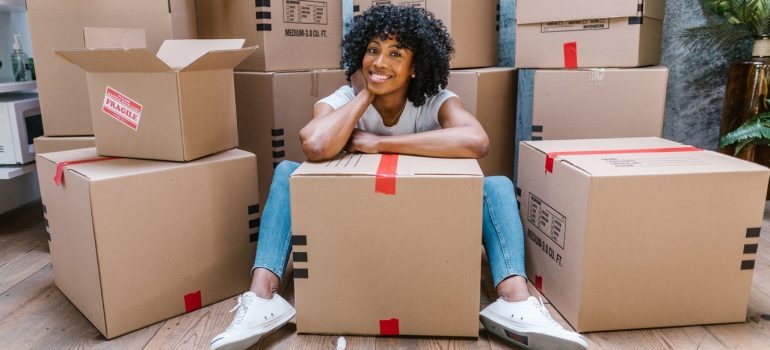 Woman smiling surrounded by boxes