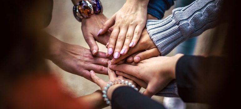 A number of hands from different people stacked on top of one another