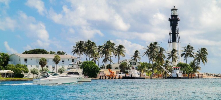 An ocean water with a houses, palms and lighthouse, and a yacht, you see when leaving Deerfield Beach for Highland Beach.