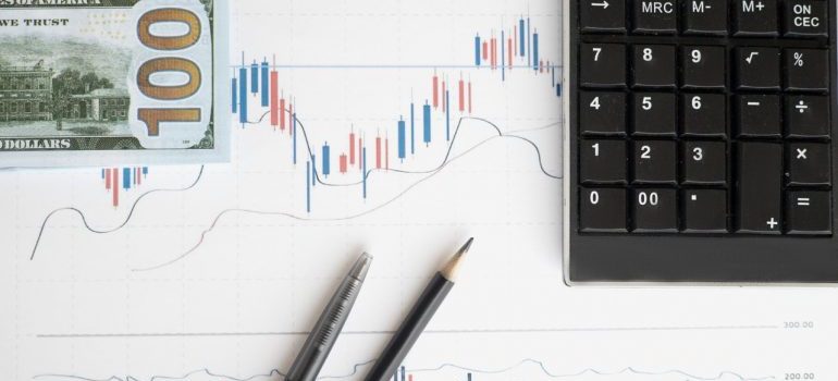 Dollar bill, a chart, pencils and calculator