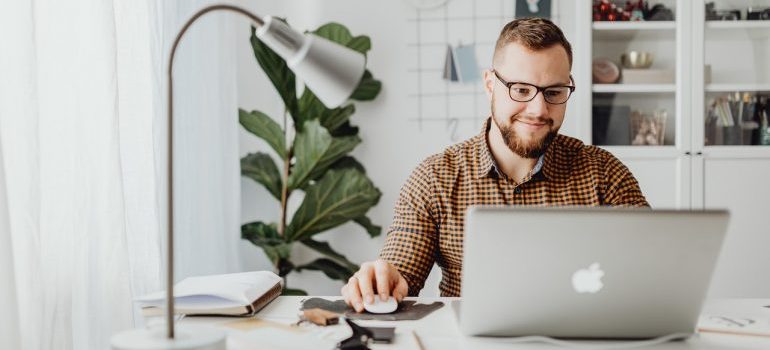 A man sitting at a desk doing work on his laptop