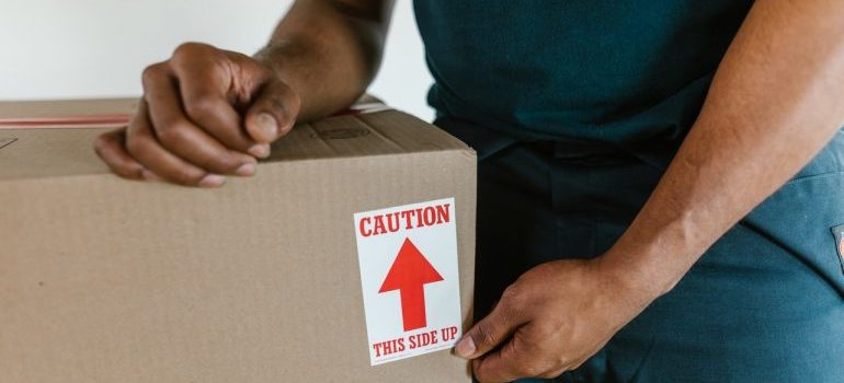 a man holding the box - organize an interstate move