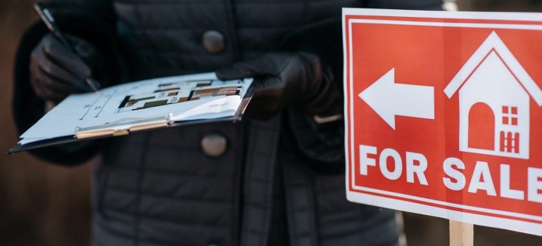 For sale sign and man in a jacket