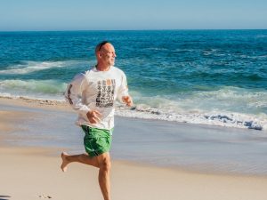 A man running alongside a beach