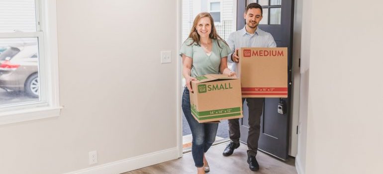 Woman and man carrying boxes