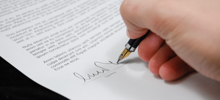 a hand signing the contract