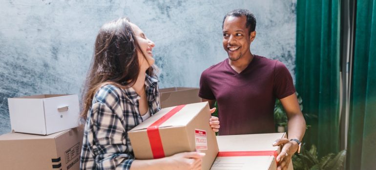 couple carrying moving boxes