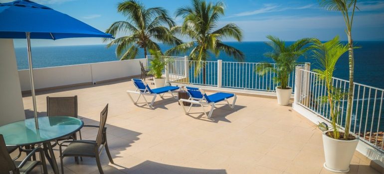 A balcony with chairs, overlooking the ocean, a place to relax after relocating to Boca Raton.