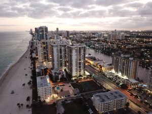 Buildings, beach and ocean at dusk. 